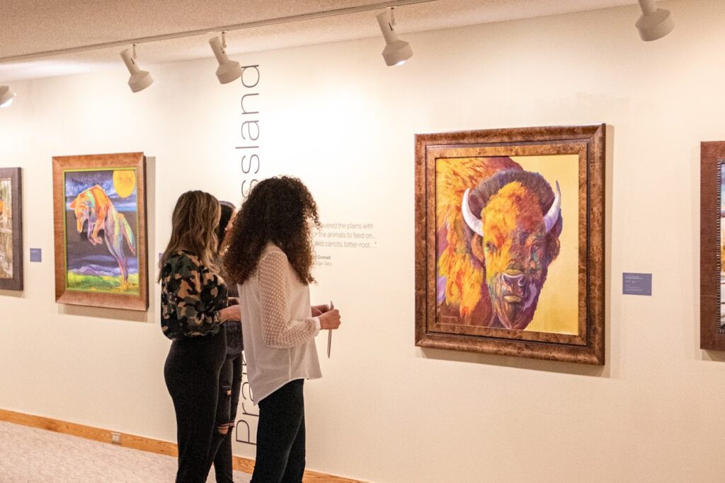 Three women look at artwork in a local museum in Great Falls, MT