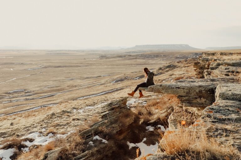 A woman sitting on a cliff in Great Falls, MT